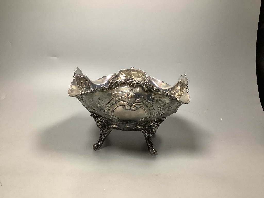 A late Victorian embossed silver fruit bowl, decorated with scrolls, baskets of fruit and masks, by Walter & John Barnard